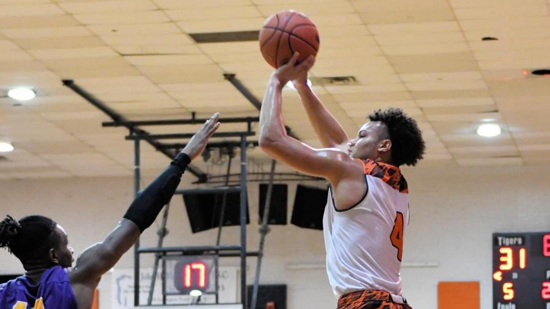 Basketball Player Shoots Over Defender