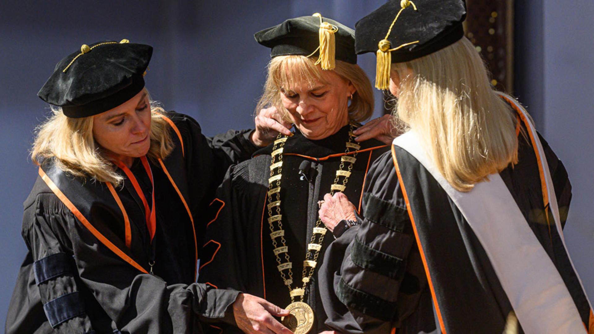 Board of Trustees members Michelle Pedigo and Granetta Blevins place the Presidential Chain of Office on President Rosemary A. Allen.