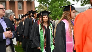 Students walk down the aisle during Commencement